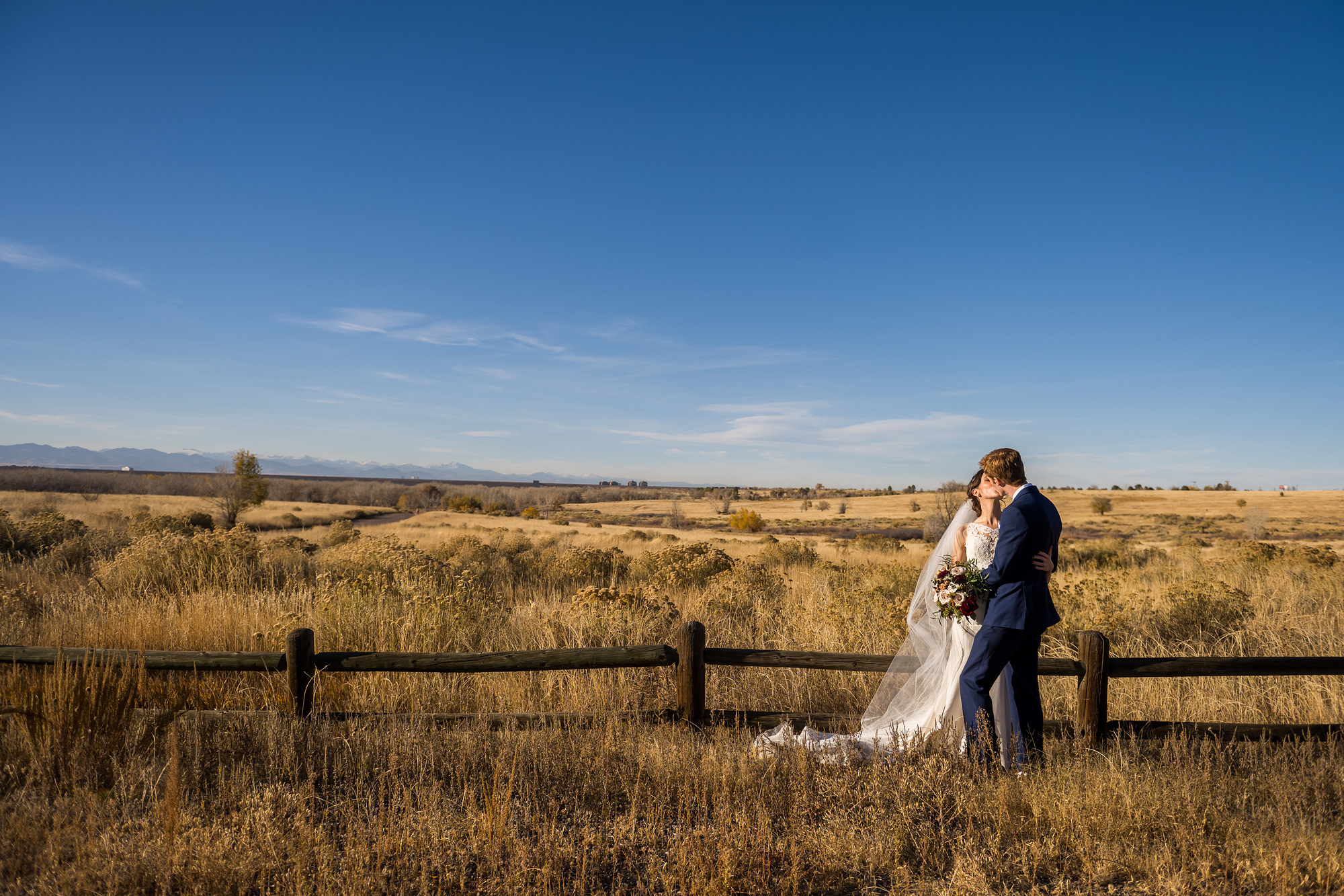 Bride and groom kiss at Cherry Creek State Park in Aurora, Colorado.