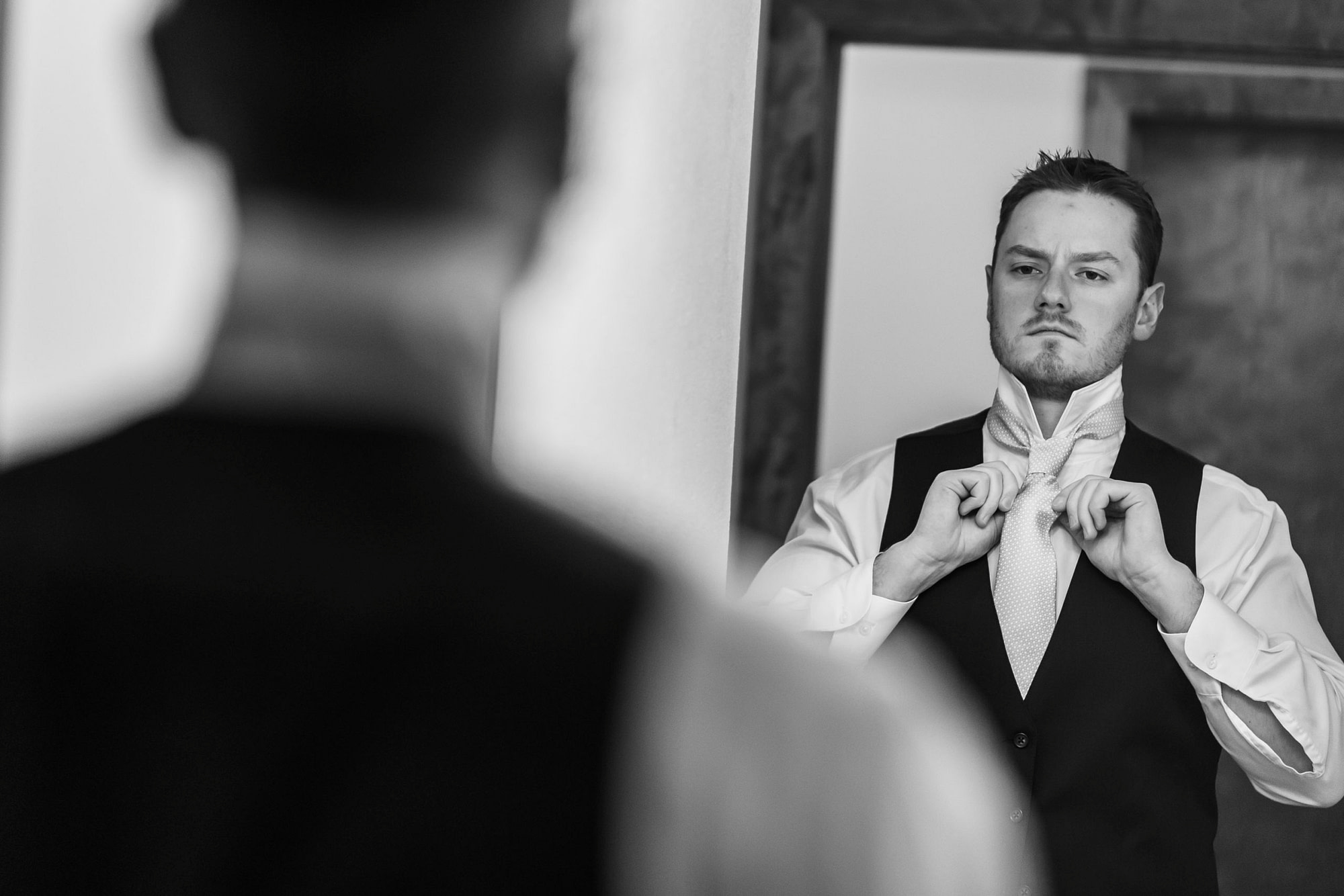 The groom adjusts his tie during his YMCA of the Rockies wedding in Estes Park, Colorado.