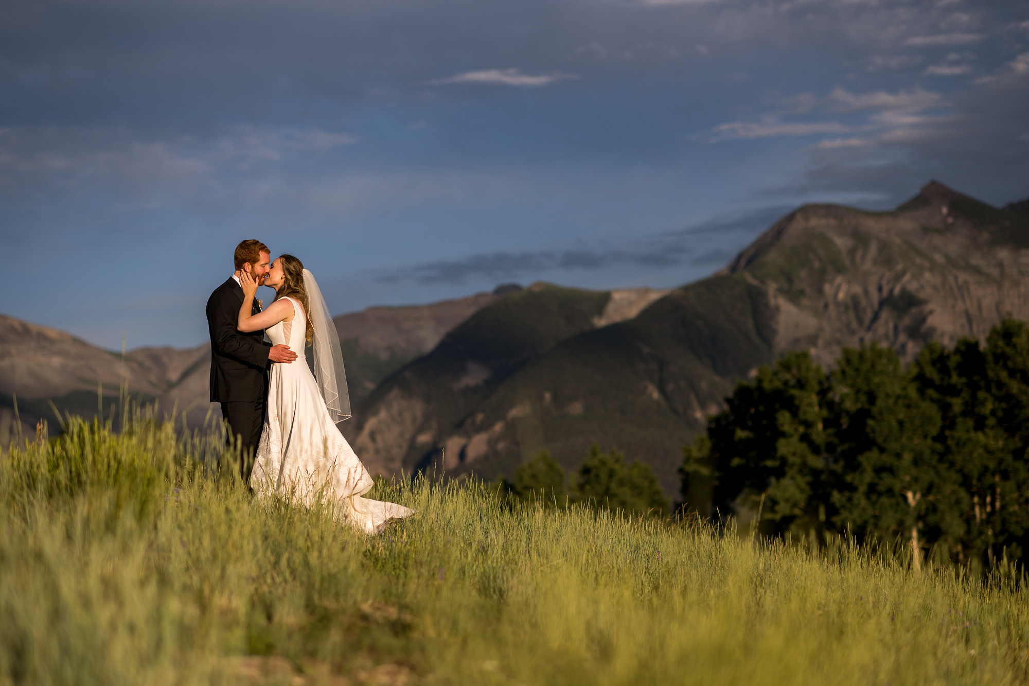 Bride and groom kiss at sunset during Telluride, Colorado, wedding.