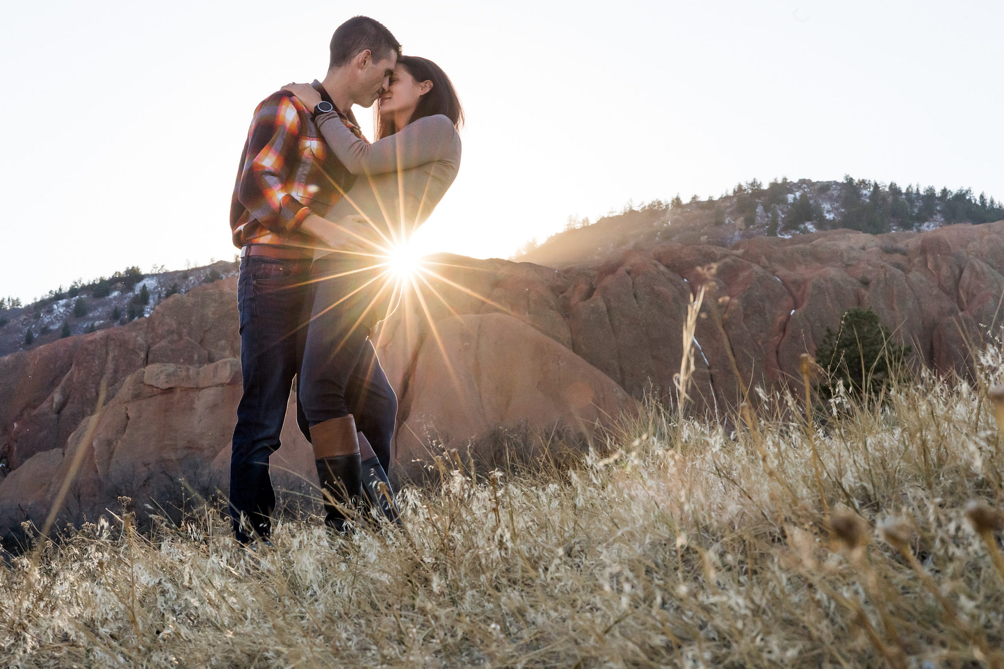 Victoria and Justin embrace in Roxborough State Park Littleton for their engagement session.