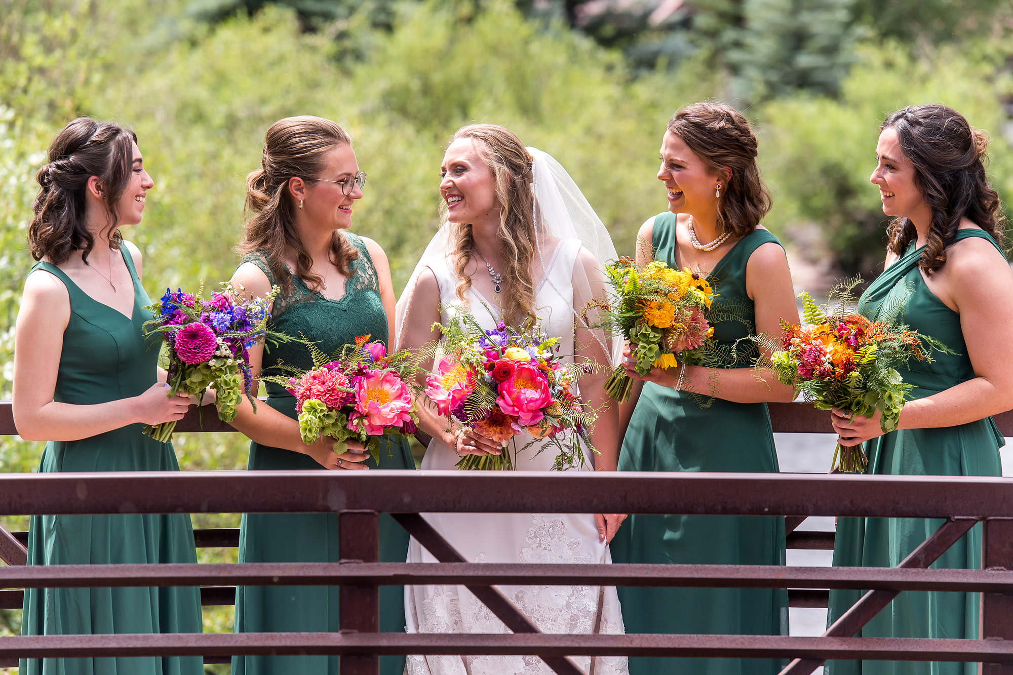 The bride and her bridesmaids laugh on a bridge in downtown Telluride, Colorado.