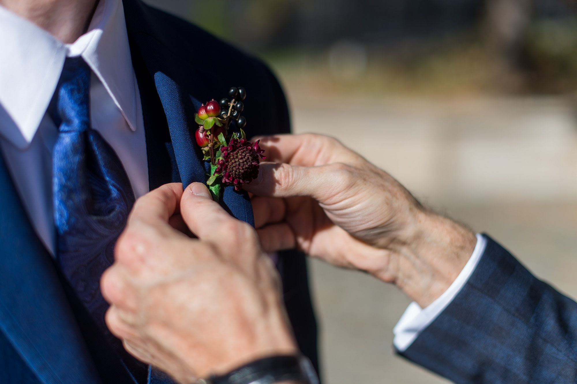 The groom's boutonnière is secured before his Cathedral Basilica of the Immaculate Conception wedding in Denver, Colorado.