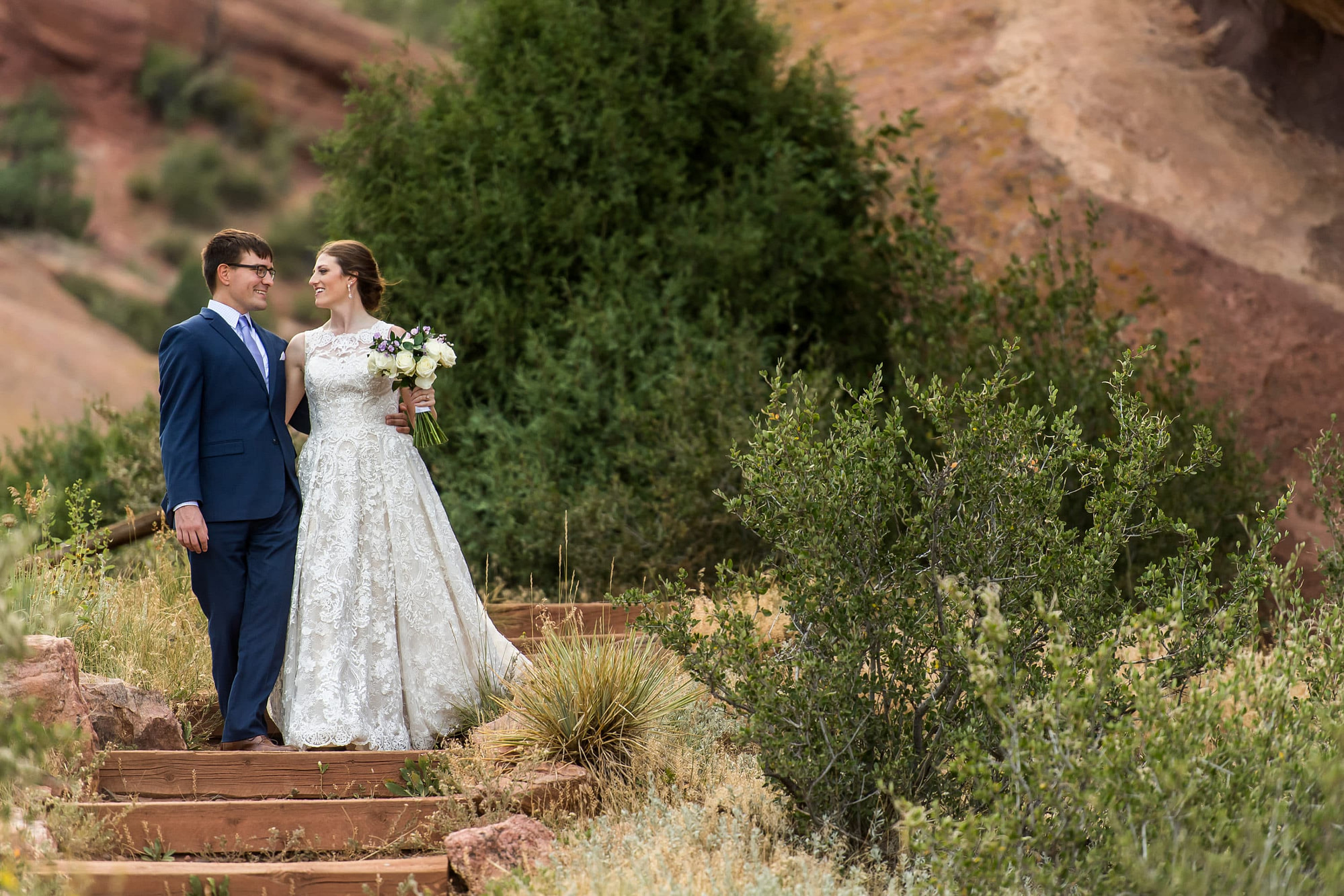 Bride and groom look at each other during Red Rocks wedding photos at Red Rocks Park and Amphitheater in Denver, Colorado, with Stacy and Andrew.