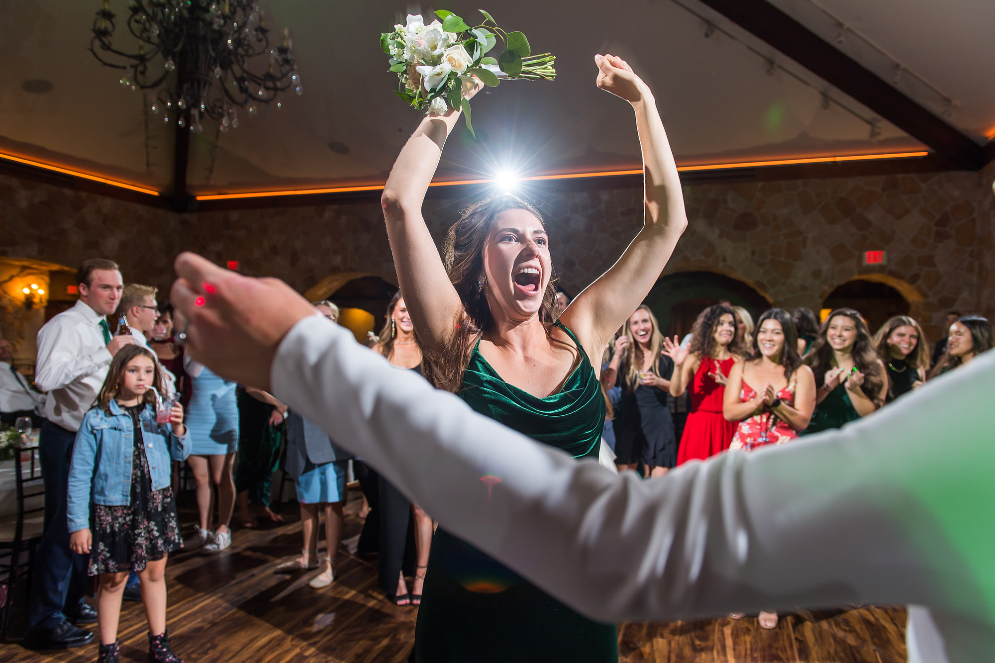 Bridesmaid reacts to catching the bouquet at Baldoria on the Water wedding venue in Lakewood, Colorado.