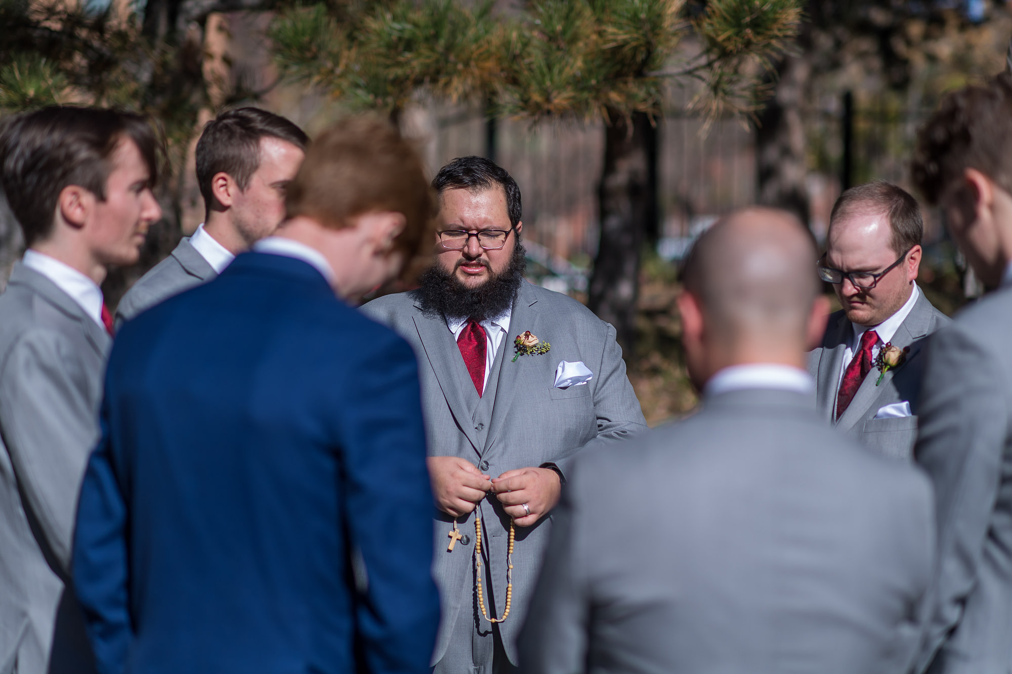Groomsmen pray over the groom before his Cathedral Basilica of the Immaculate Conception wedding in Denver, Colorado.