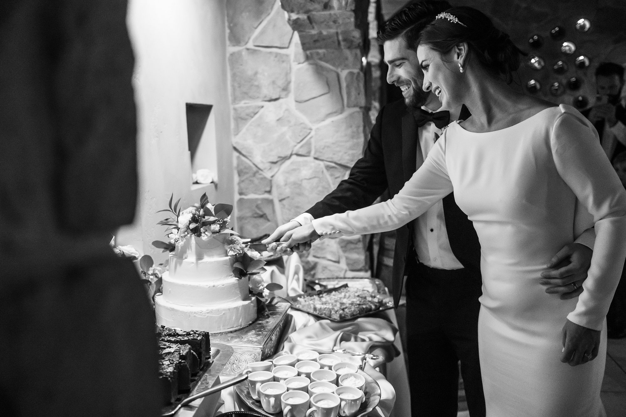 Bride and groom cut cake at Baldoria on the Water wedding venue in Lakewood, Colorado.
