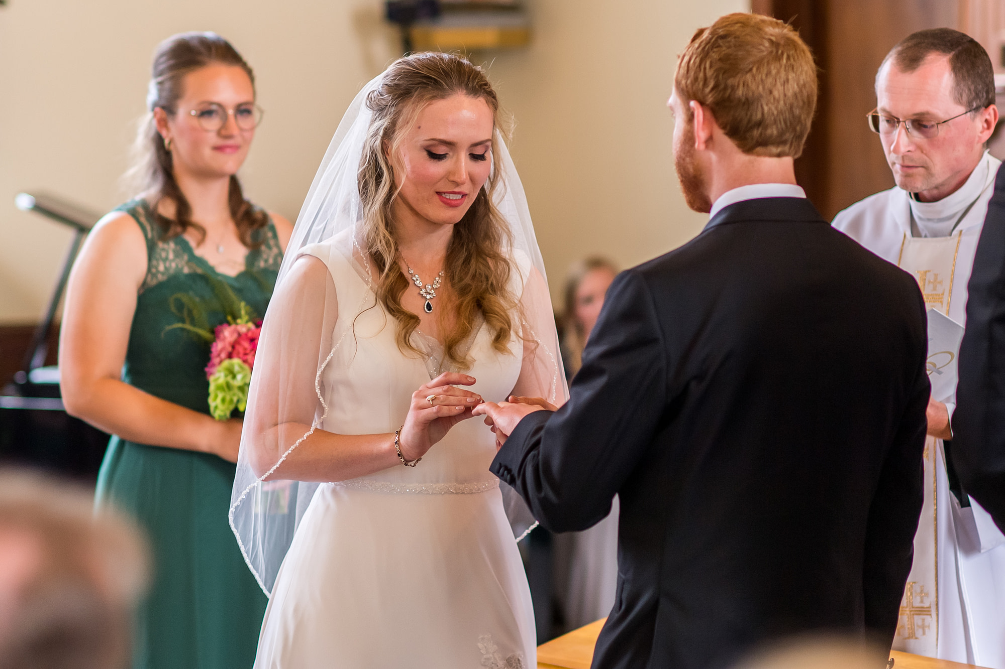 The bride puts a ring on the groom's finger during a Telluride, Colorado, wedding at St. Patrick's Catholic Church.