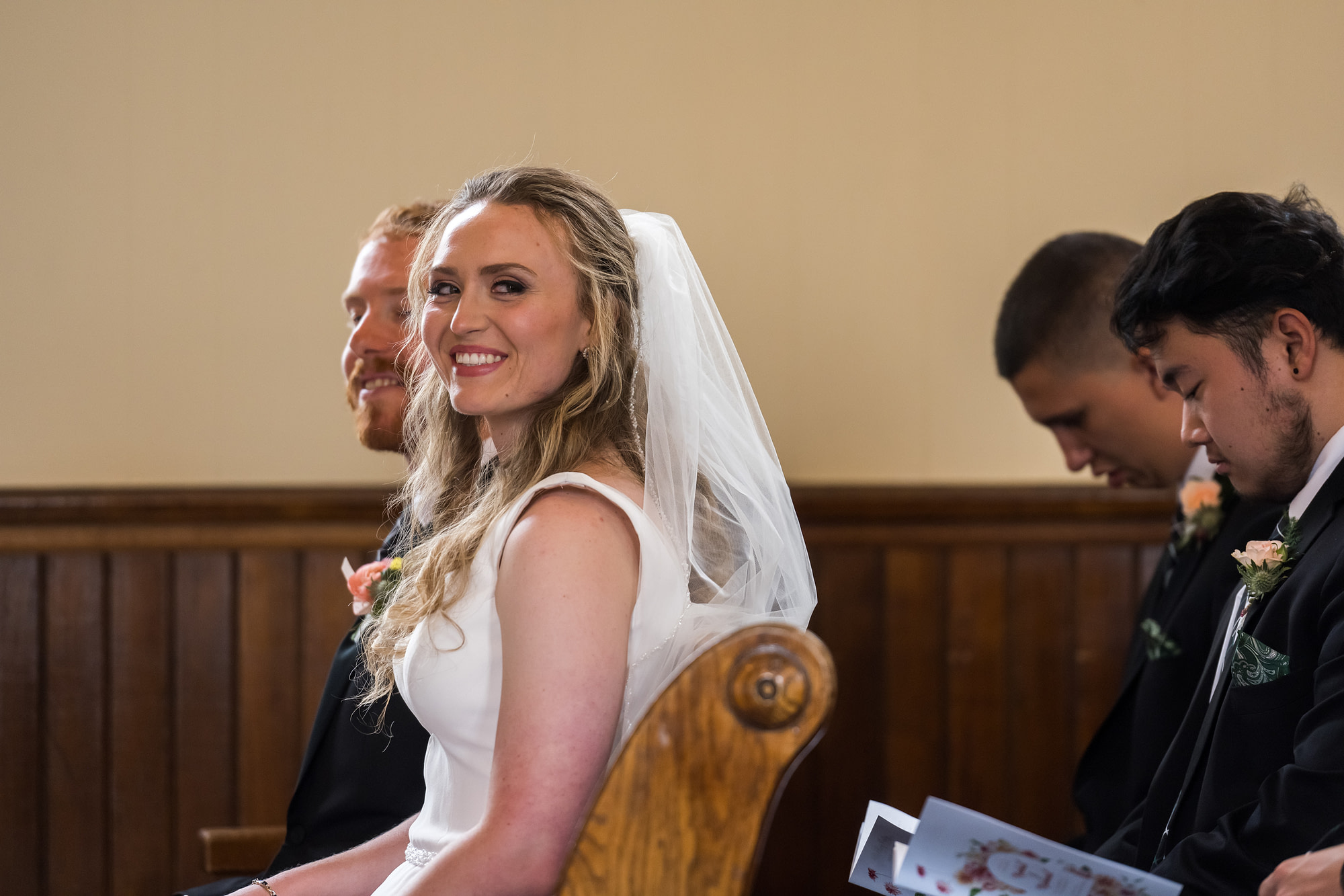 The bride looks back at guests during her Telluride, Colorado, wedding at St. Patrick's Catholic Church.