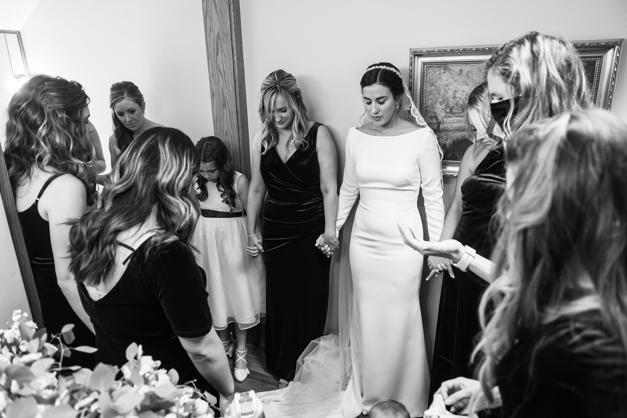 Bride prays with bridesmaids during her Holy Ghost Church Denver wedding in Denver, Colorado.