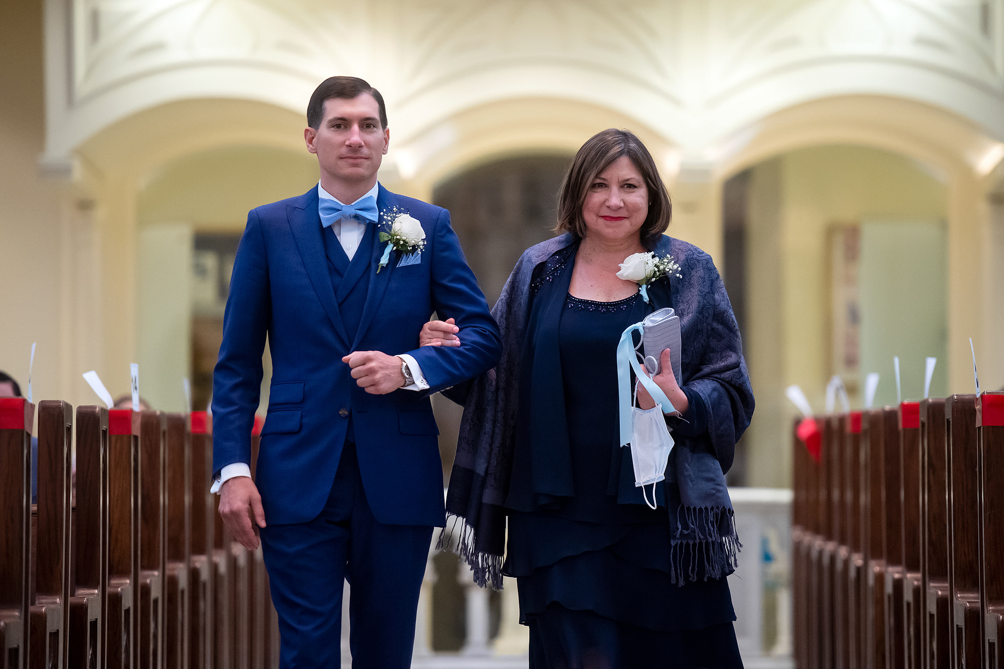 Groom processes in with his mother at his wedding at the Cathedral Basilica of the Immaculate Conception in Denver, Colorado.