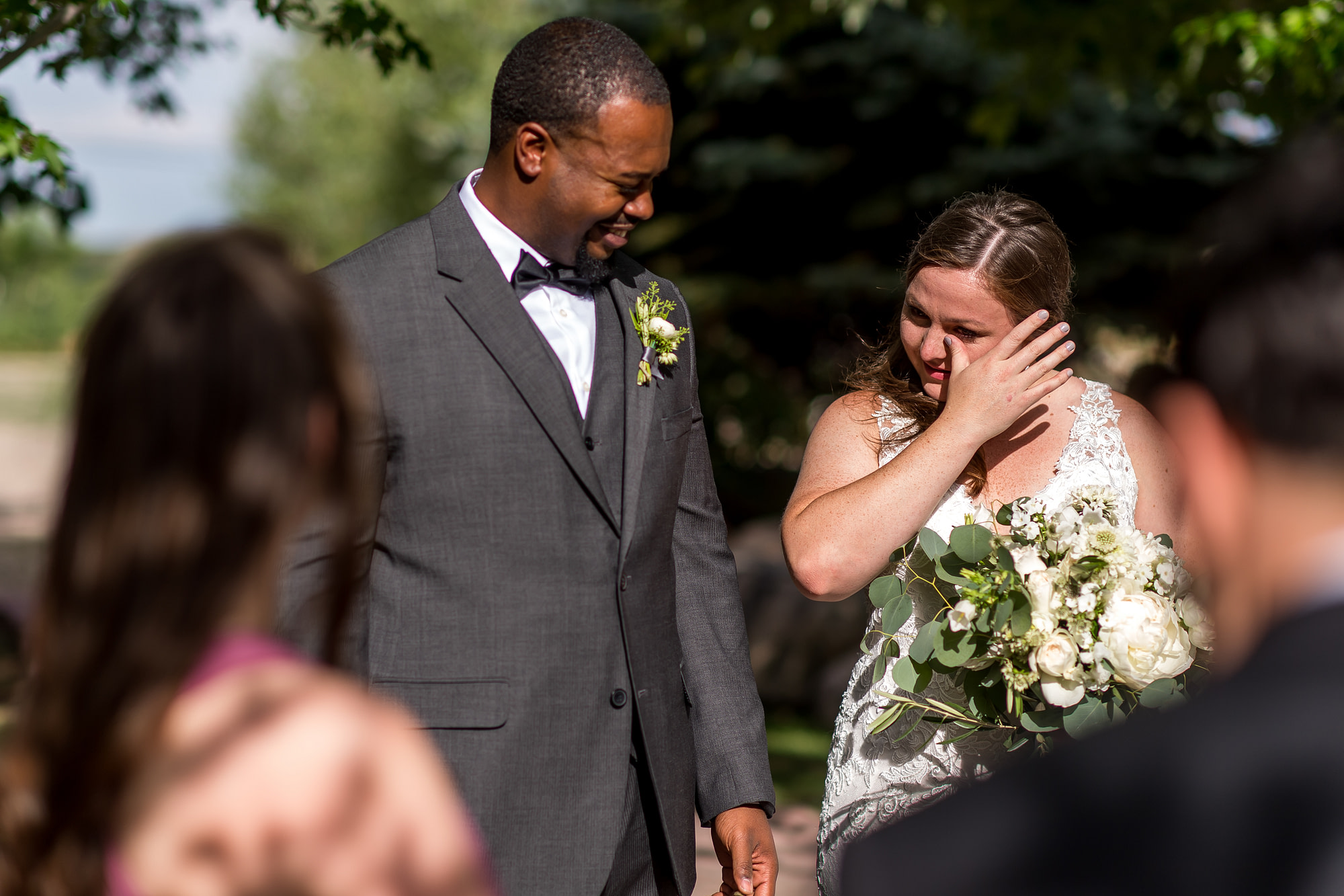 The bride wipes away a tear after a Greenbriar Inn wedding in Boulder, Colorado.