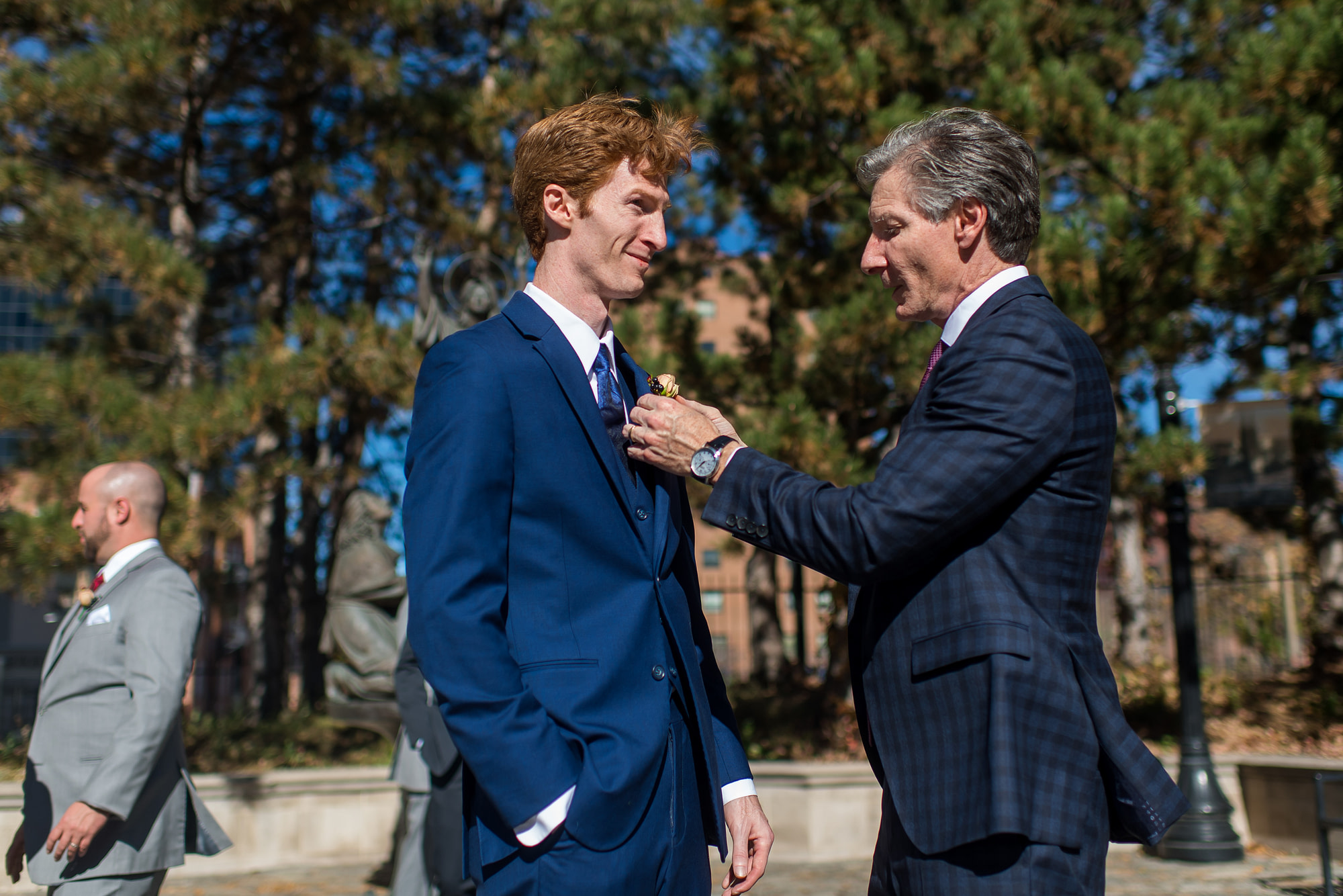 The father of the groom secures his son's boutonnière before his Cathedral Basilica of the Immaculate Conception wedding in Denver, Colorado.