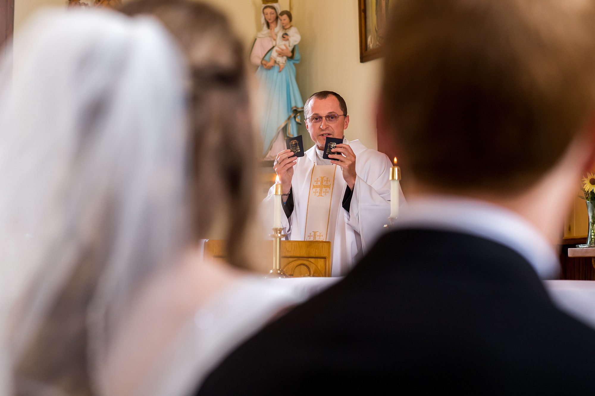 The priest holds two rosaries during a Telluride, Colorado, wedding at St. Patrick's Catholic Church.