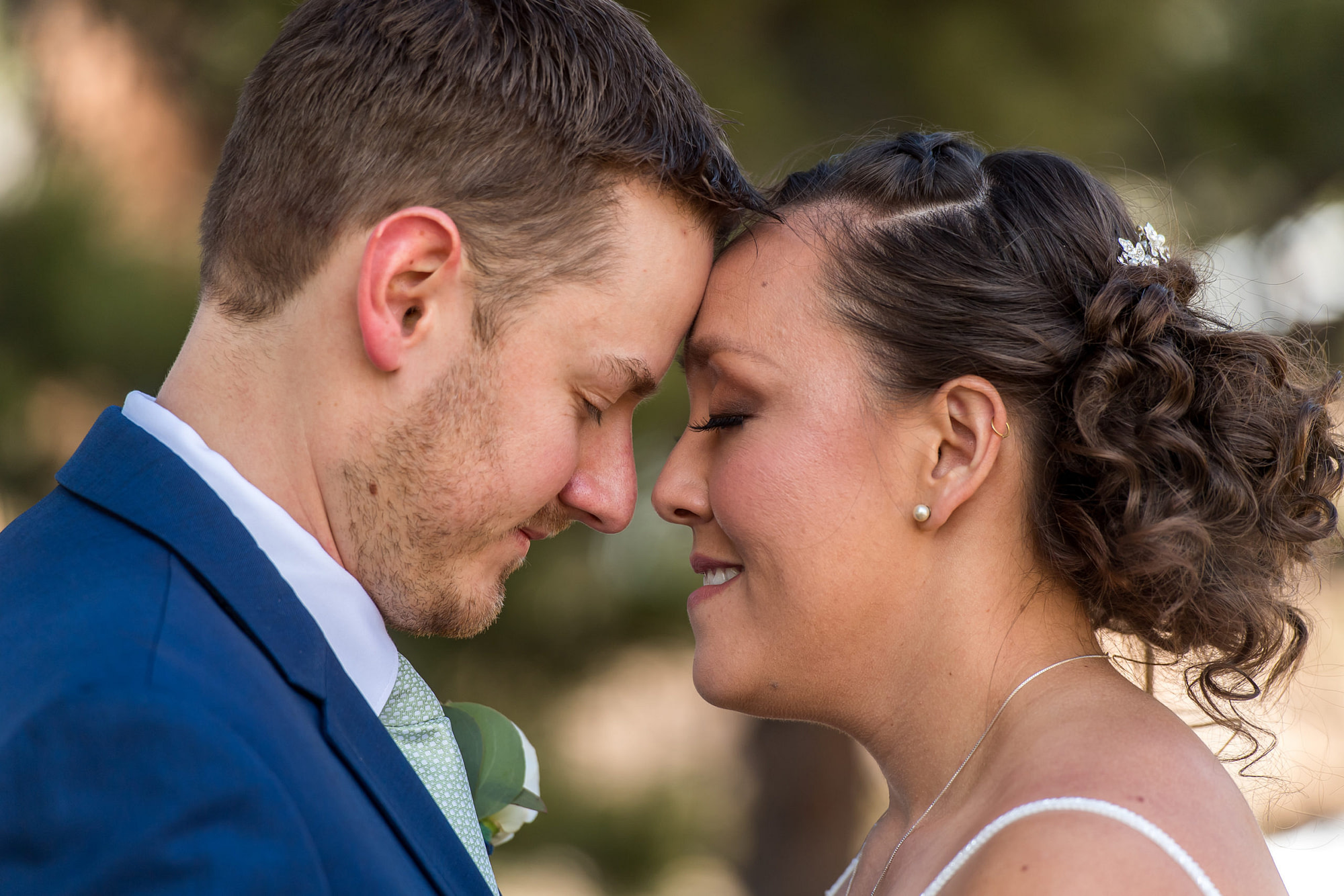 The bride and groom lean their foreheads together during their YMCA of the Rockies wedding in Estes Park, Colorado.