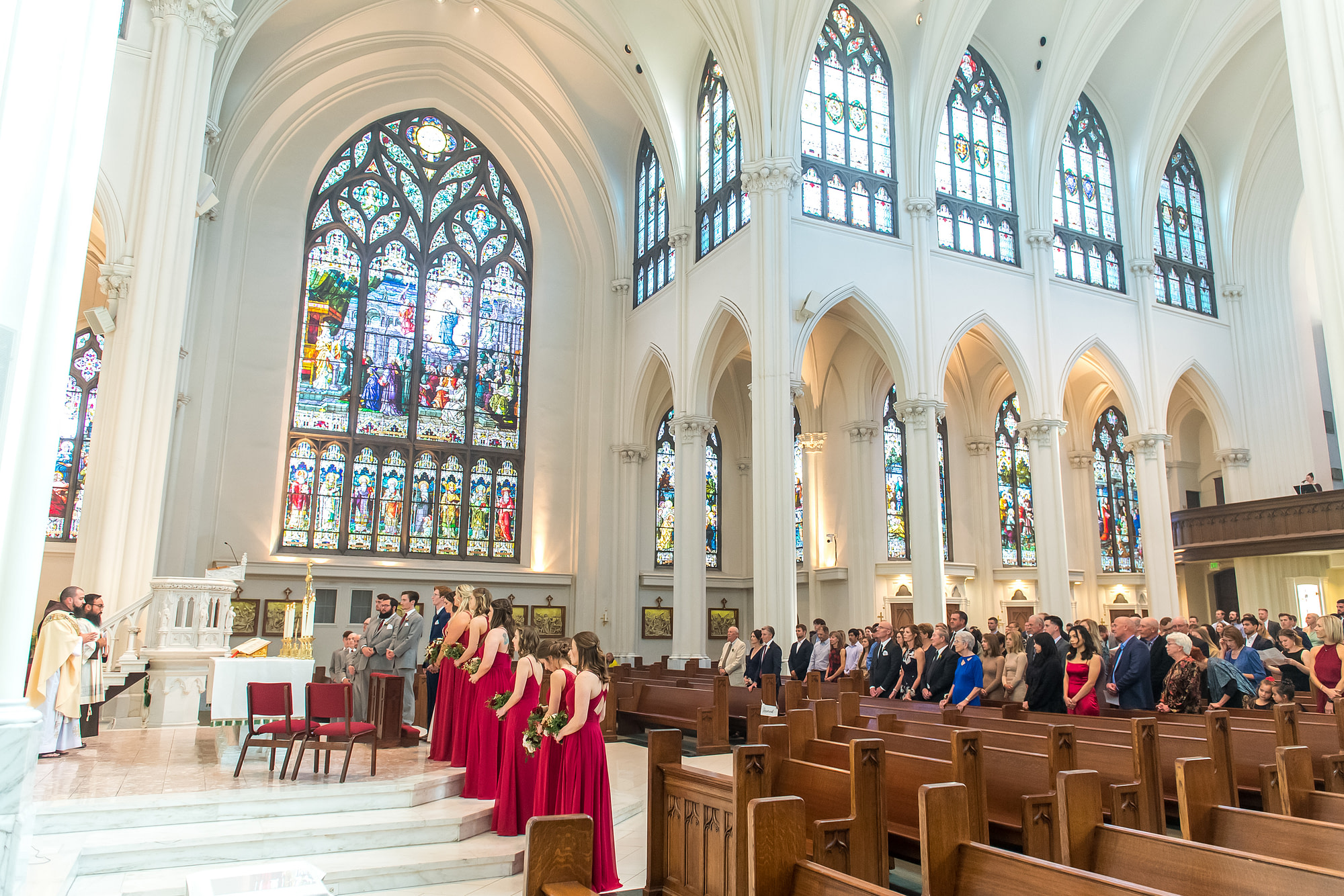 The bride and groom look on with their bridal party during a Cathedral Basilica of the Immaculate Conception wedding in Denver, Colorado.