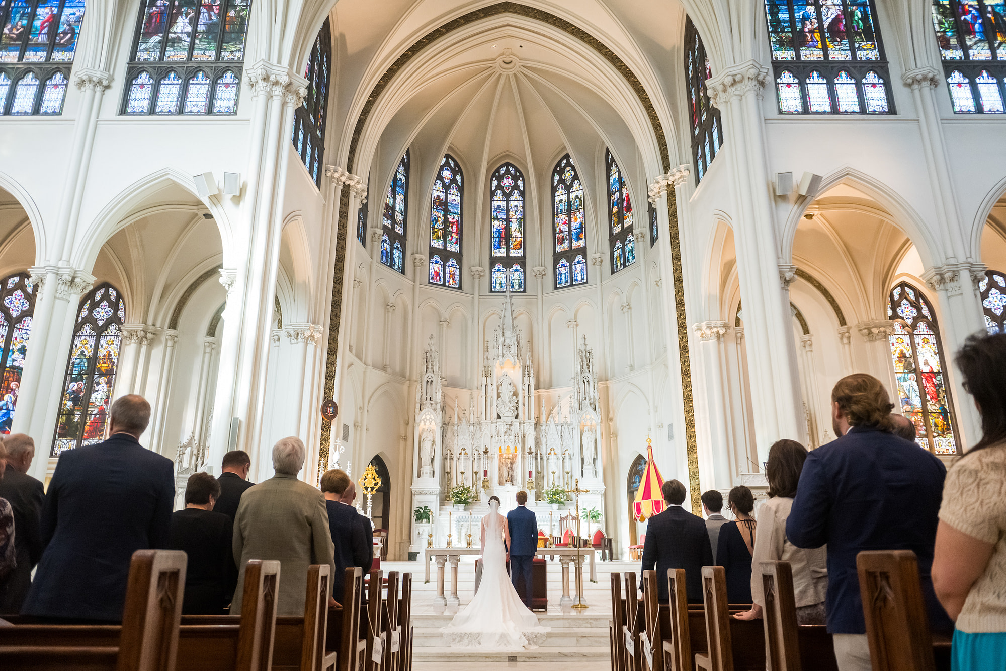 Bride and groom look on during a Cathedral Basilica of the Immaculate Conception wedding in Denver, Colorado.
