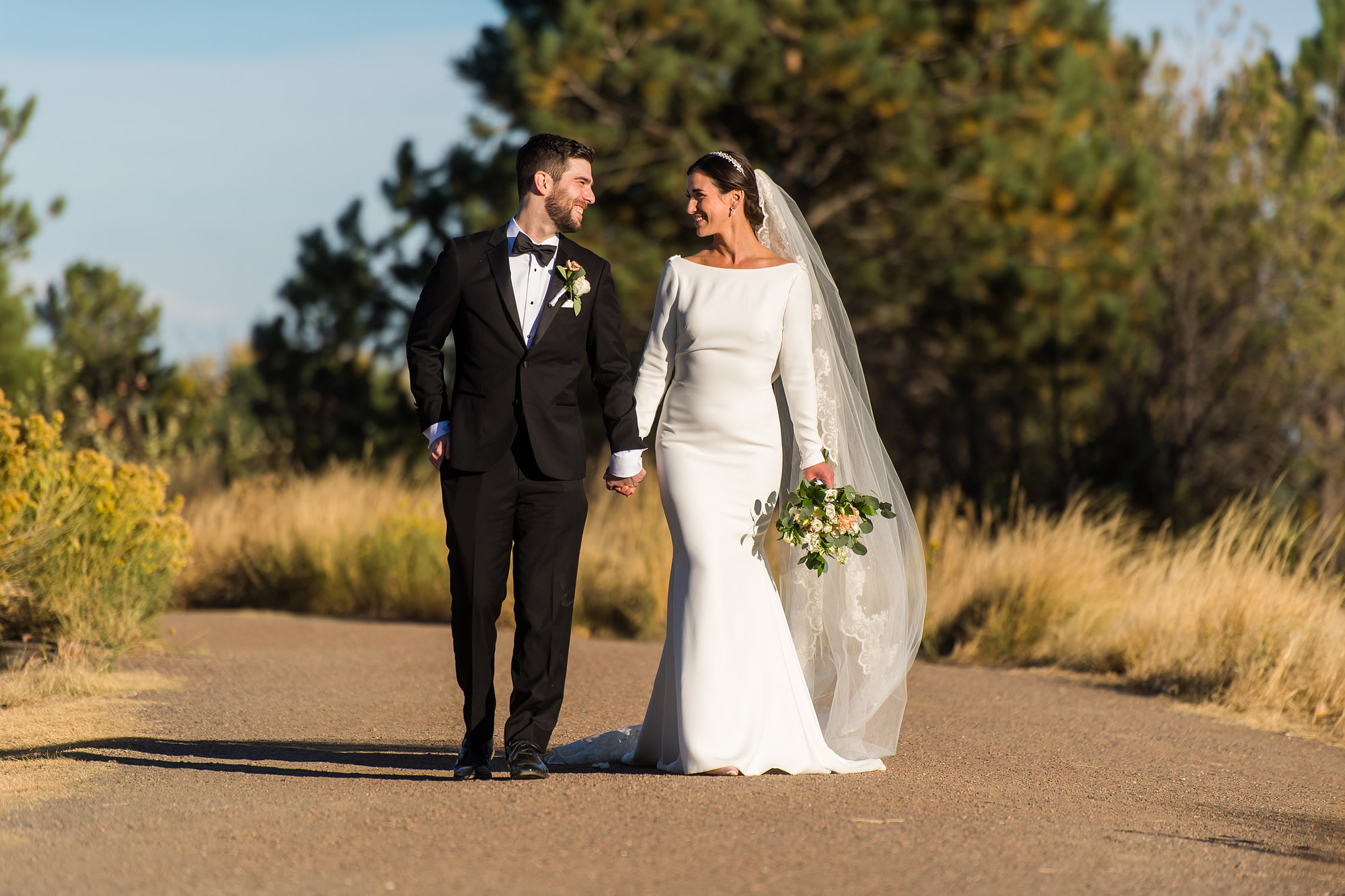 Bride and groom walk during wedding photo portraits at Belmar Park in Lakewood, Colorado.