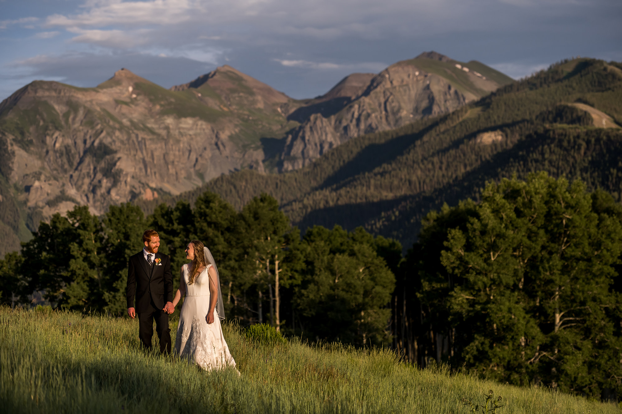 Bride and groom walk at sunset during Telluride, Colorado, wedding.